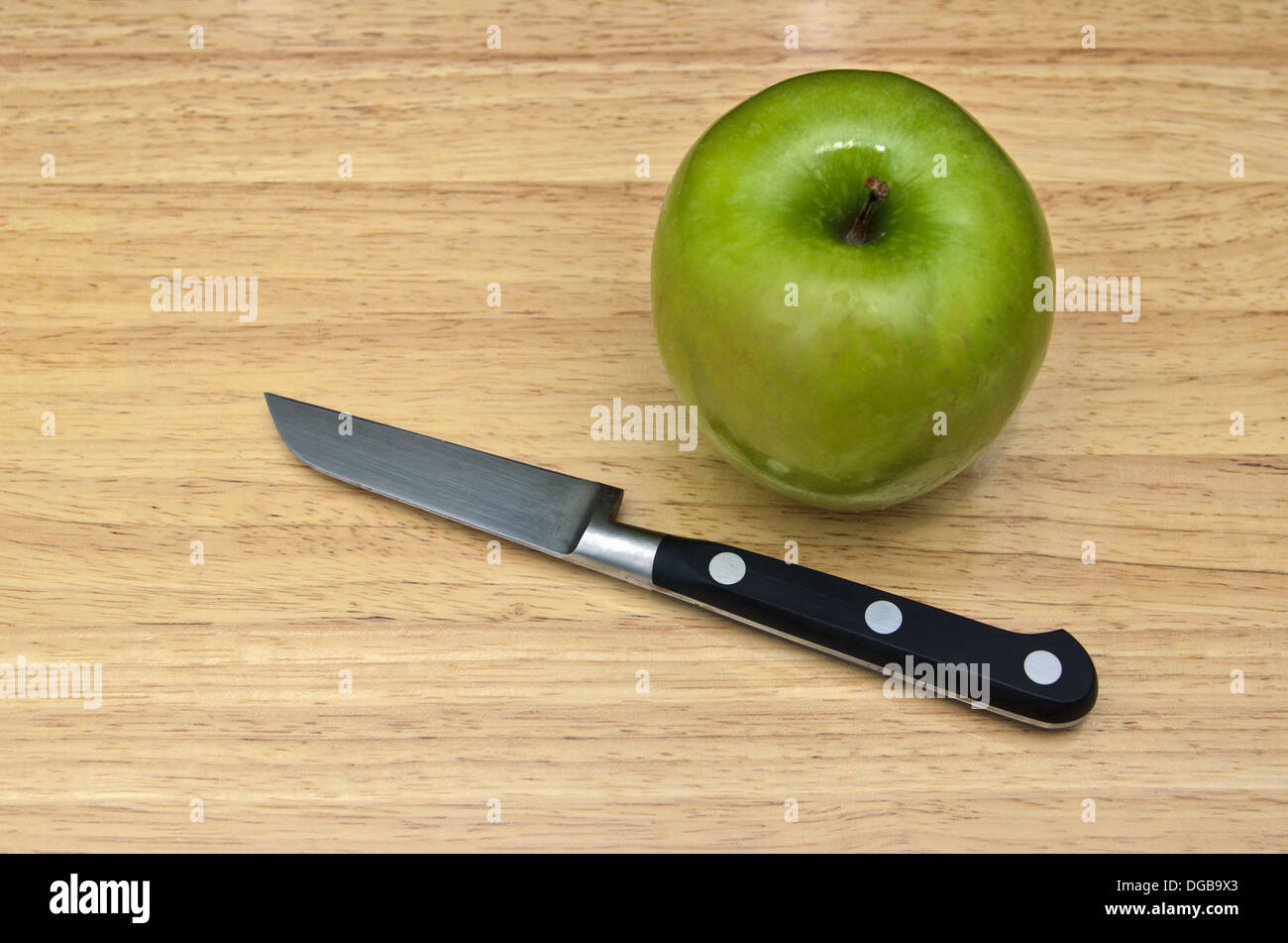 La pomme verte avec un couteau sur la table en bois Banque D'Images