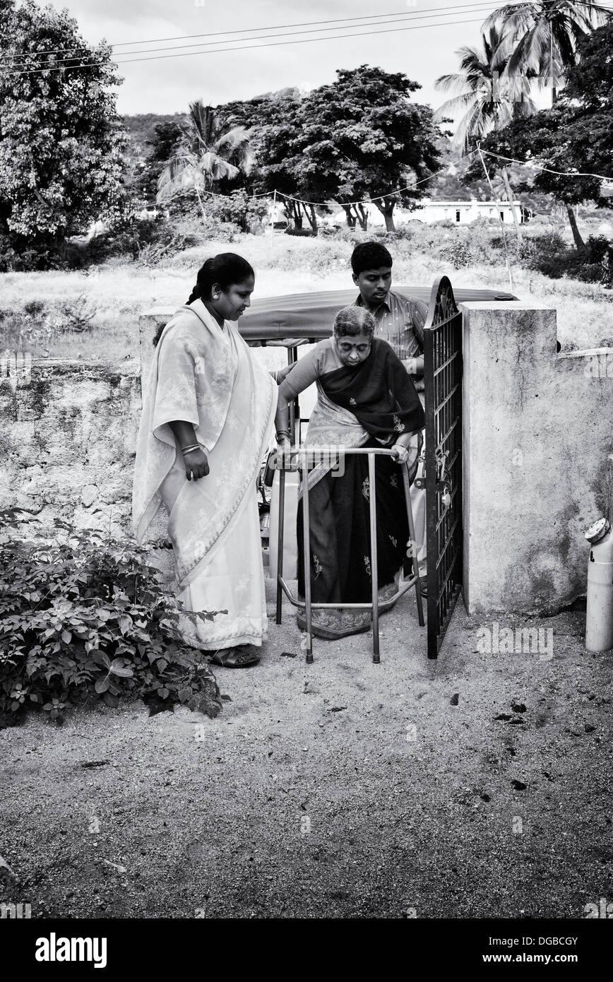 Personnes âgées femme indienne avec un déambulateur à Sri Sathya Sai Baba l'hôpital mobile. L'Andhra Pradesh, Inde. Monochrome Banque D'Images