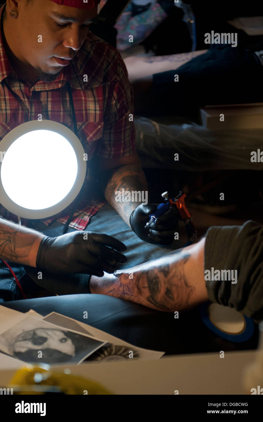 Un artiste de tatouage à l'encre de tatouage / personnes un leg Banque D'Images