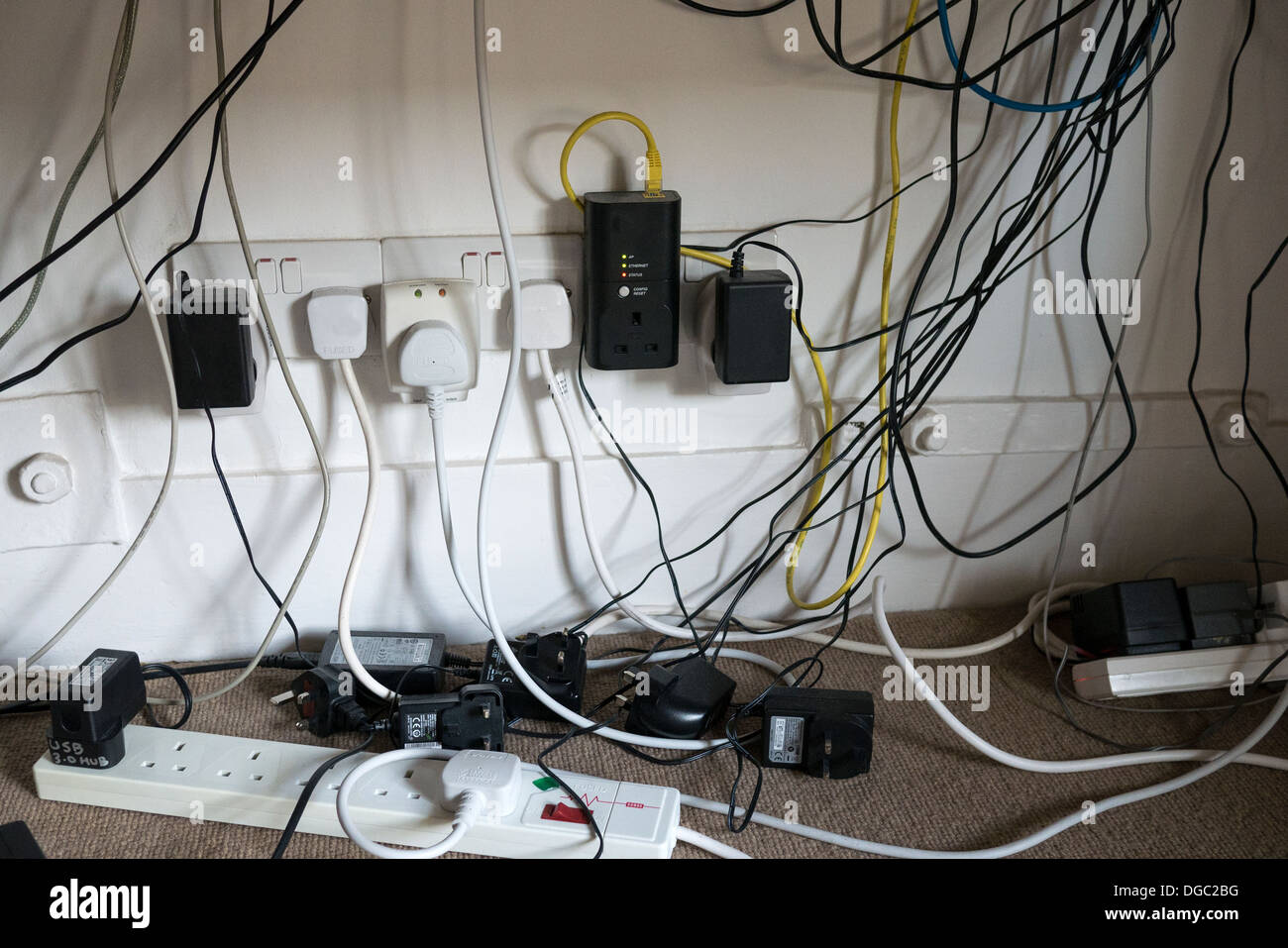 Un fouillis de câbles d'alimentation et les câbles de l'ordinateur sous un bureau Crédit photo : David Levenson / Alamy Banque D'Images