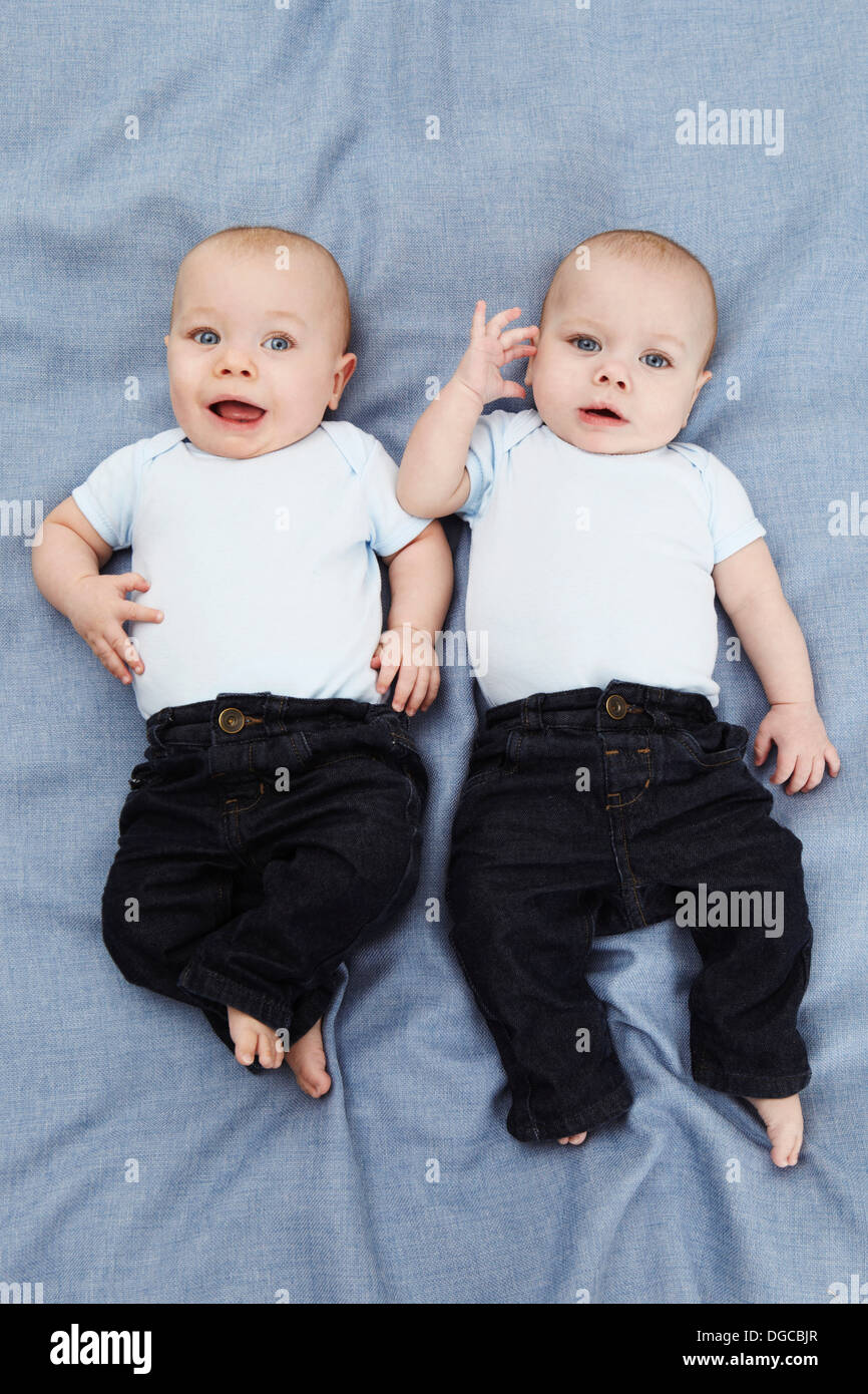 Portrait de deux garçons de bébé couché sur bleu, overhead view Banque D'Images