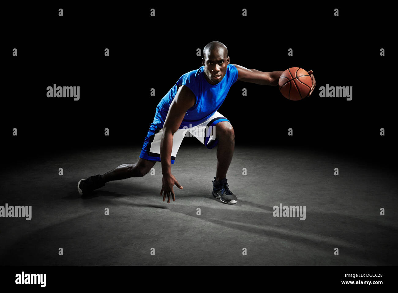 Studio shot of basketball player holding ball Banque D'Images