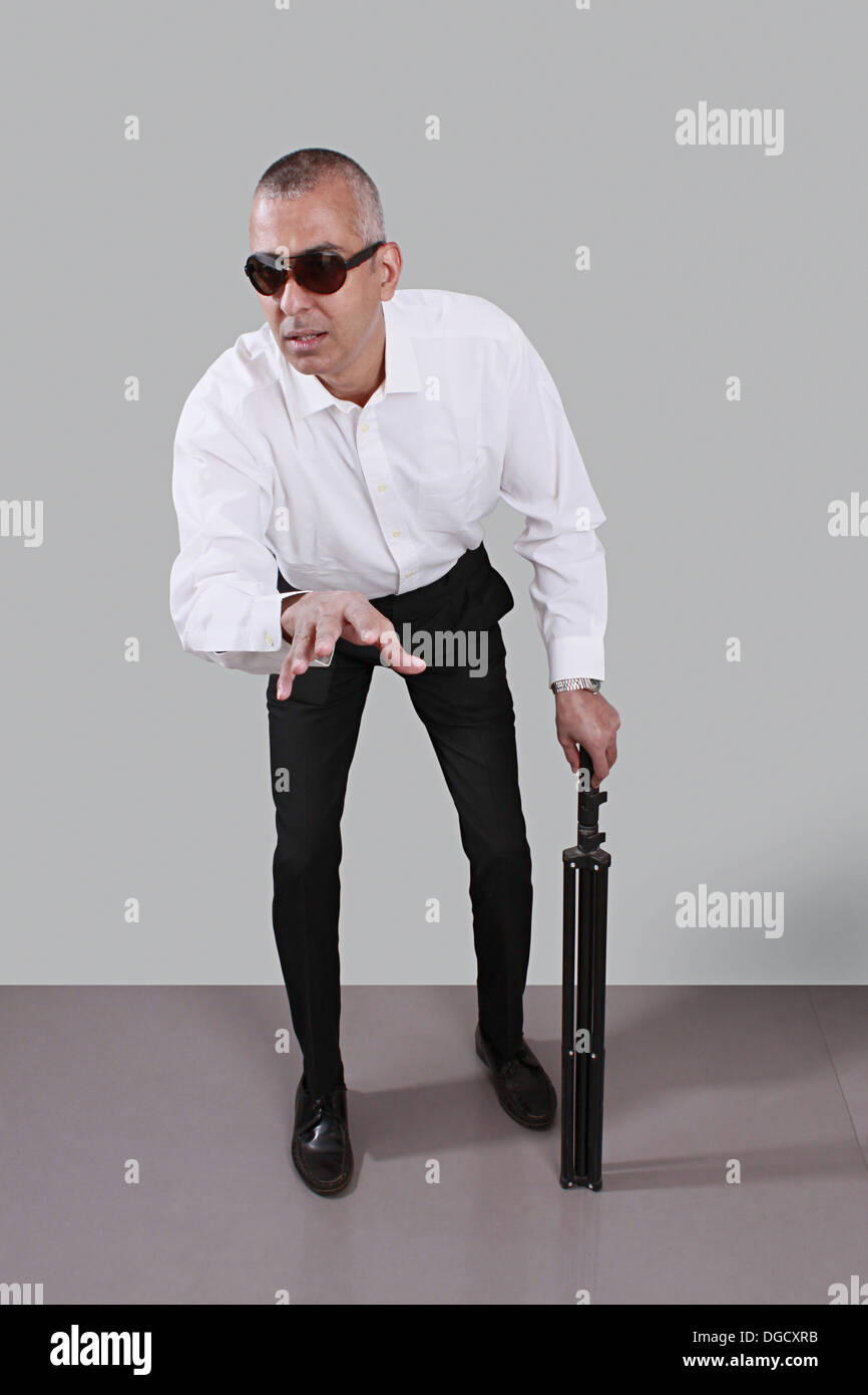 Aveugle d'âge moyen, lunettes noires et stick, debout avec un  pressentiment, expression perdue Photo Stock - Alamy
