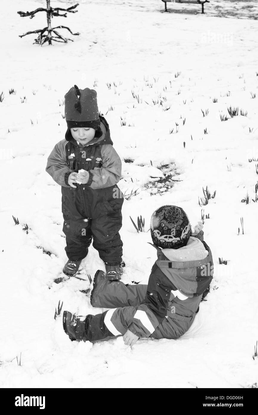 De jeunes garçons jouent dans la neige noir et blanc Banque D'Images