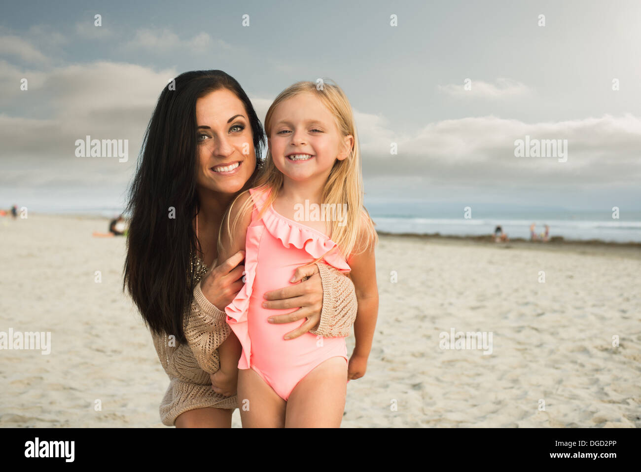 Young woman smiling with daughter on beach, portrait Banque D'Images
