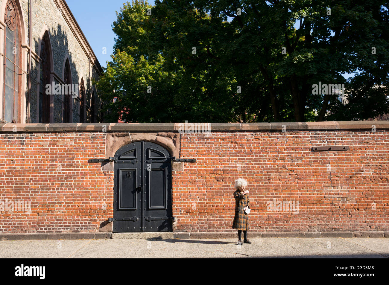 Femme aux cheveux blancs dans Nolita en attente d'une voiture à New York City Banque D'Images