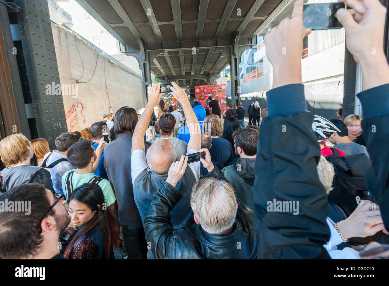 New York, USA. 18 octobre 2013. Les amateurs d'art de rue à la mode troupeau Chelsea West district Gallery à New York pour voir la dix-huitième tranche de l'art graffiti de Banksy, une collaboration avec les artistes brésiliens, Os Gemeos. Cette tranche est configuré comme une exposition de musée dans un lot vide sous le parc High Line complet avec le "musée" des gardes pour gérer le contrôle des foules. L'insaisissable artiste de rue, c'est la création d'œuvres autour de la ville chaque jour pendant le mois d'octobre. Crédit : Richard Levine/Alamy Live News Banque D'Images