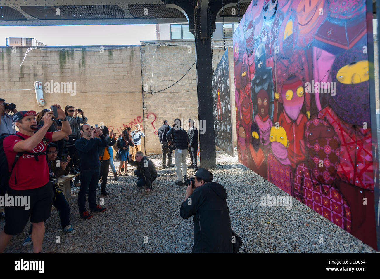 New York, USA. 18 octobre 2013. Les amateurs d'art de rue à la mode troupeau Chelsea West district Gallery à New York pour voir la dix-huitième tranche de l'art graffiti de Banksy, une collaboration avec les artistes brésiliens, Os Gemeos. Cette tranche est configuré comme une exposition de musée dans un lot vide sous le parc High Line complet avec le "musée" des gardes pour gérer le contrôle des foules. L'insaisissable artiste de rue, c'est la création d'œuvres autour de la ville chaque jour pendant le mois d'octobre. Crédit : Richard Levine/Alamy Live News Banque D'Images