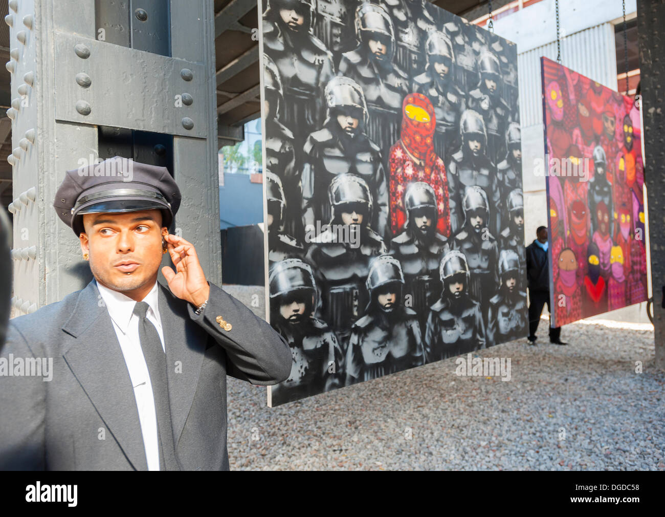 New York, USA. 18 octobre 2013. Les amateurs d'art de rue à la mode troupeau Chelsea West district Gallery à New York pour voir la dix-huitième tranche de l'art graffiti de Banksy, une collaboration avec les artistes brésiliens, Os Gemeos. Cette tranche est configuré comme une exposition de musée dans un lot vide sous le parc High Line complet avec le "musée" des gardes pour gérer le contrôle des foules. L'insaisissable artiste de rue, c'est la création d'œuvres autour de la ville chaque jour pendant le mois d'octobre. Crédit : Richard Levine/Alamy Live News Banque D'Images