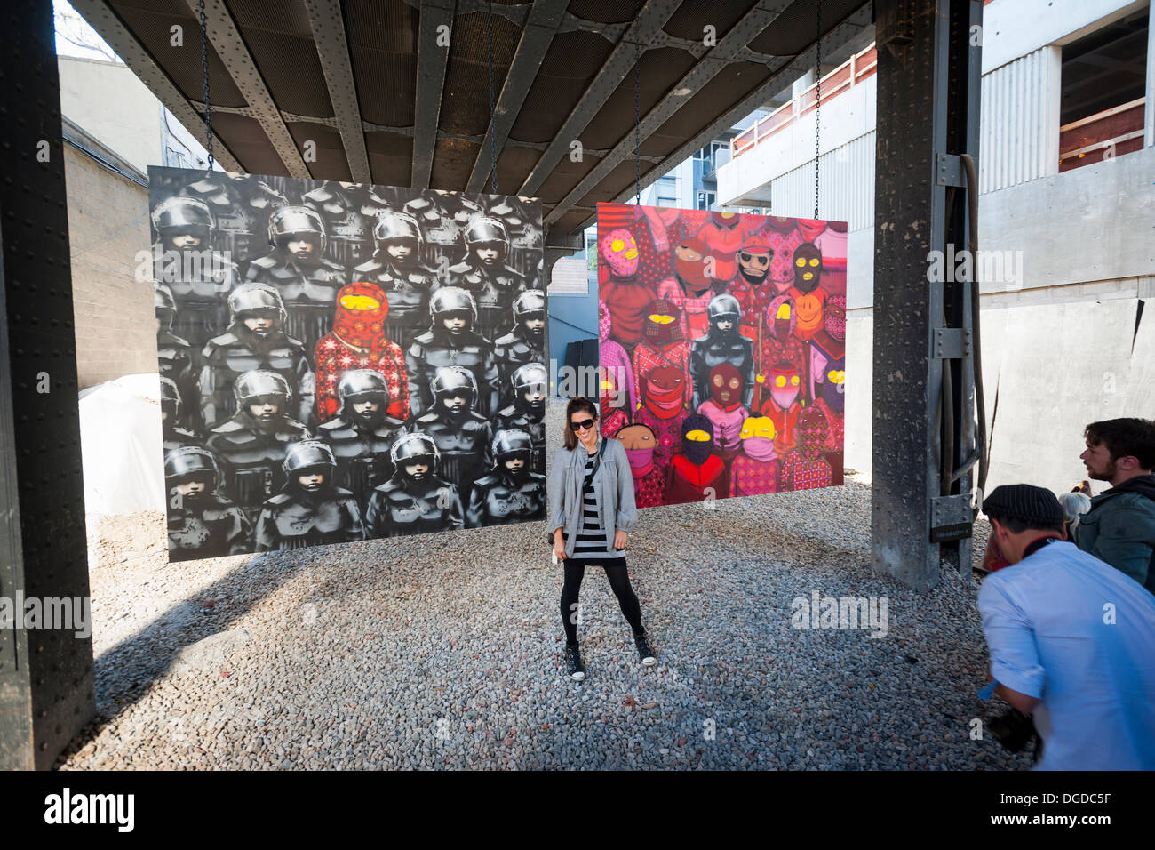 New York, USA. 18 octobre 2013. Les amateurs d'art de rue à la mode troupeau Chelsea West district Gallery à New York pour voir la dix-huitième tranche de l'art graffiti de Banksy, une collaboration avec les artistes brésiliens, Os Gemeos. Cette tranche est configuré comme une exposition de musée dans un lot vide sous le parc High Line complet avec le "musée" des gardes pour gérer le contrôle des foules. L'insaisissable artiste de rue, c'est la création d'œuvres autour de la ville chaque jour pendant le mois d'octobre. Crédit : Richard Levine/Alamy Live News Banque D'Images