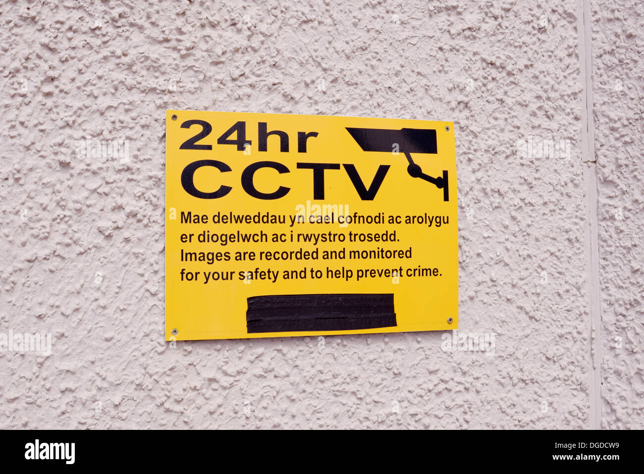 Affiche bilingue en gallois et l'anglais d'avertissement 24 heures de télévision en circuit fermé de surveillance CCTV, Pays de Galles, Royaume-Uni Banque D'Images