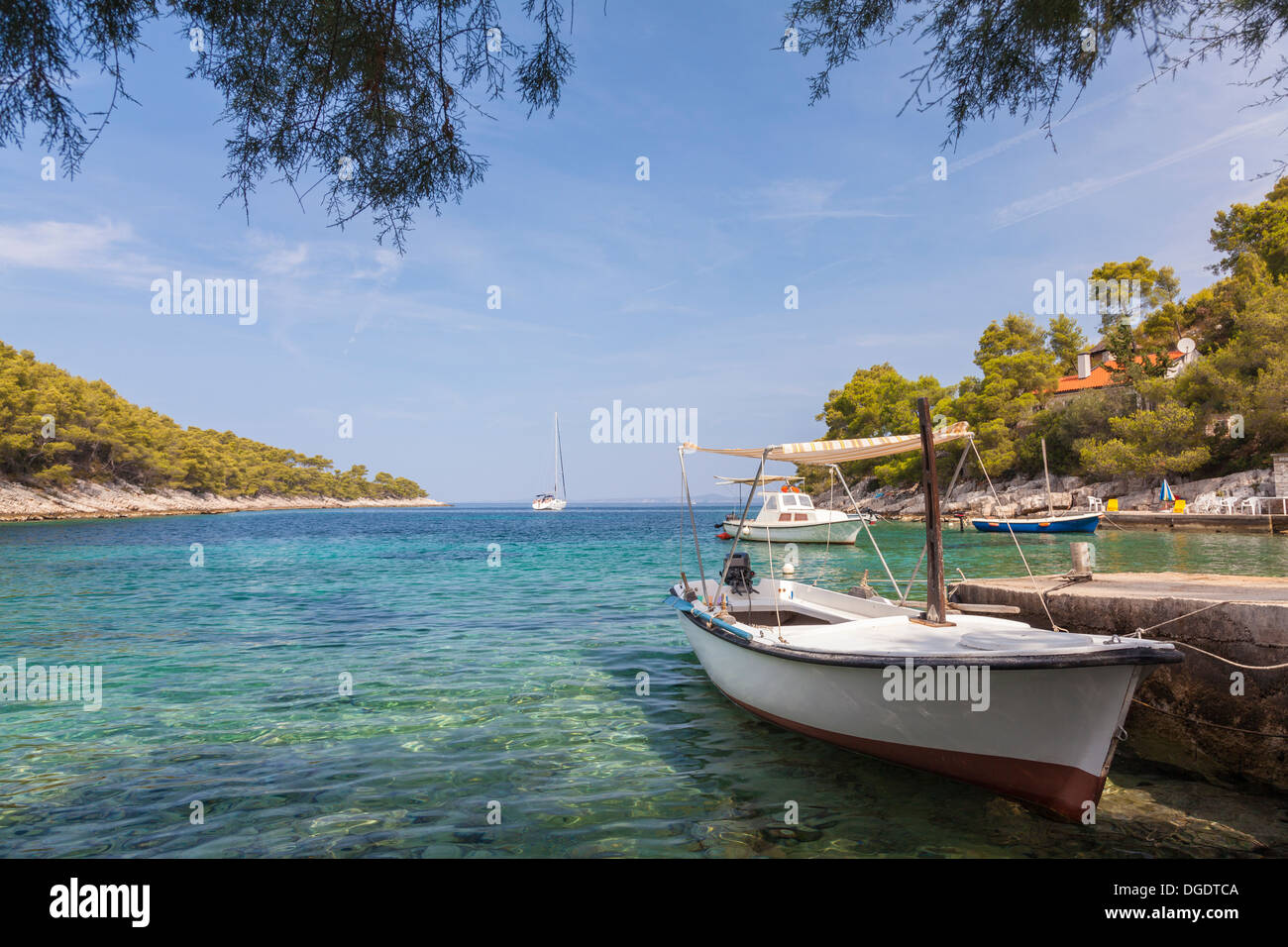 Bateaux dans un paisible lagon côte à une plage sur l'île de Hvar, Croatie Banque D'Images