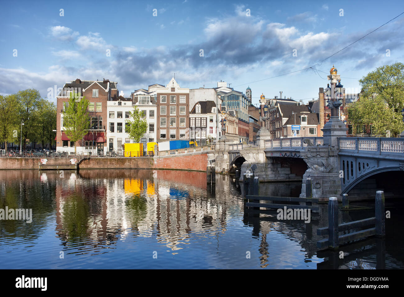 Maisons avec des réflexions sur les eaux de la rivière Amstel, dans la ville d'Amsterdam, Pays-Bas, Blue Bridge (Blauwbrug)) sur la droite. Banque D'Images