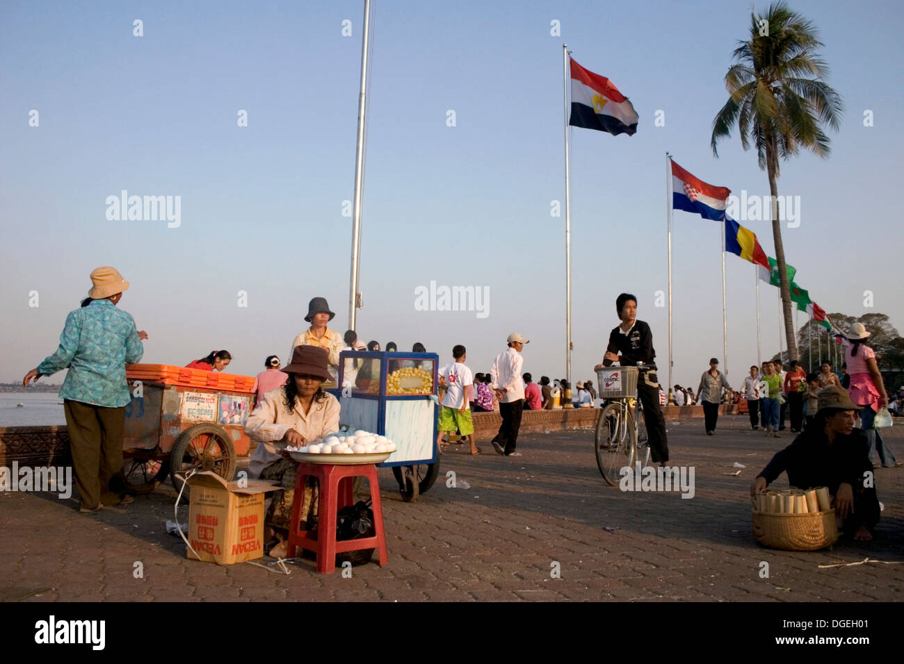 Une femme est la vente des oeufs alors que les gens profiter de la promenade le long du fleuve sur la rive du Mékong à Phnom Penh, Cambodge. Banque D'Images