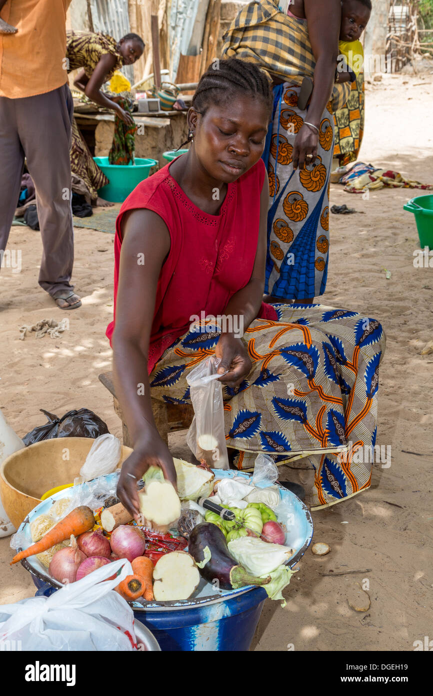Le Sénégal. Cette femme tient un approvisionnement en légumes frais à portée de main pour vente rapide lorsque d'autres femmes n'ont pas le temps de courir sur le marché. Banque D'Images