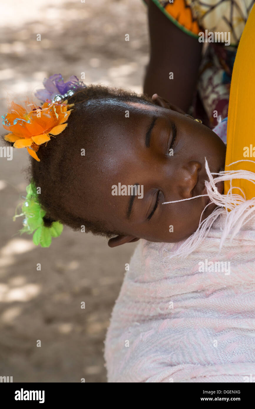Baby Girl Sleeping tout en étant transporté sur le dos de la mère, Fass Njaga Choi, North Bank Region, la Gambie. Banque D'Images