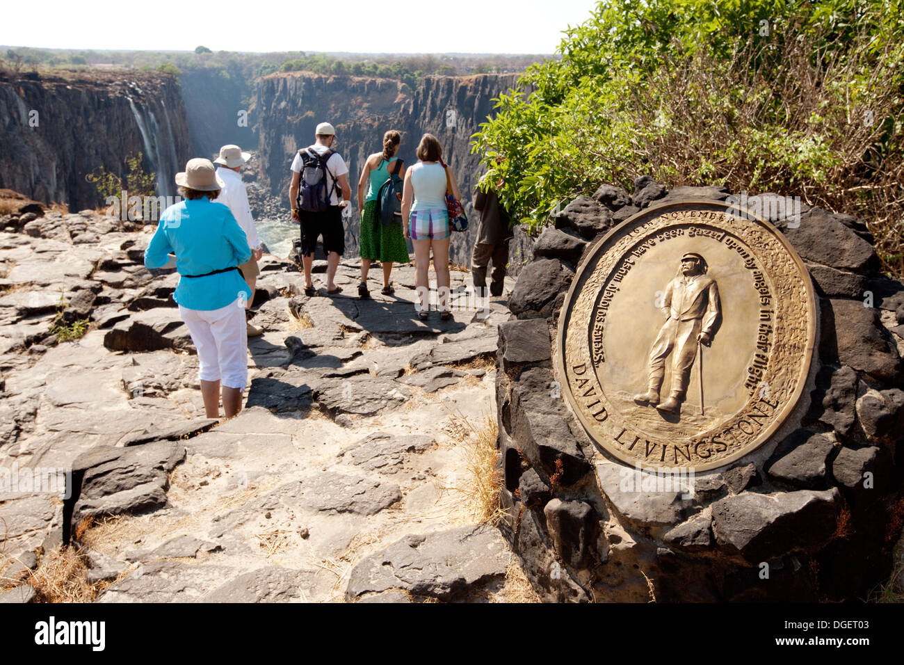 Les touristes à la plaque commémorative à David Livingstone en haut des Chutes Victoria, l'île de Livingstone, Zambie, Afrique du Sud Banque D'Images