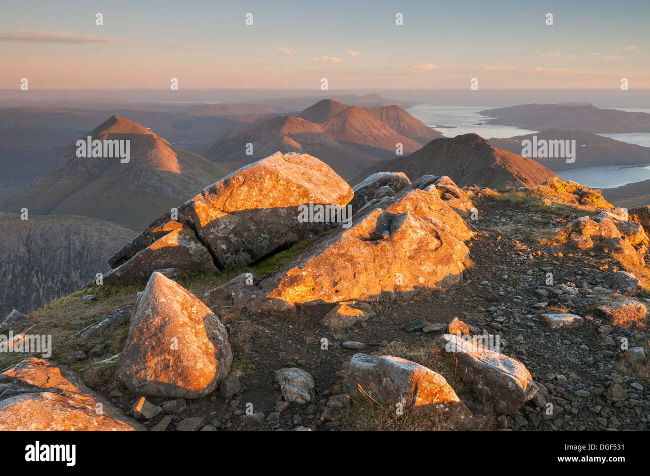 Rochers ensoleillée sur le sommet du bla Bheinn à l'aube, avec Marsco et les Cuillin hills rouge en arrière-plan, l'île de Skye Banque D'Images