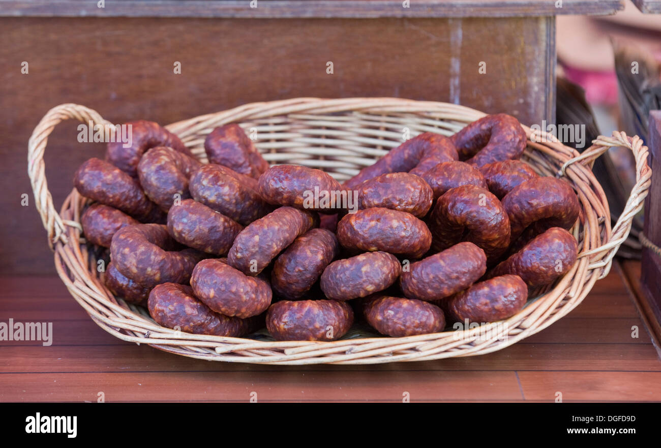 Chorizo Sanglier dans un panier en osier en vente sur un étal du Marché Français Banque D'Images