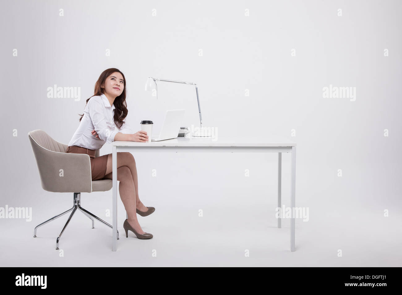 Une business woman sitting at desk Banque D'Images