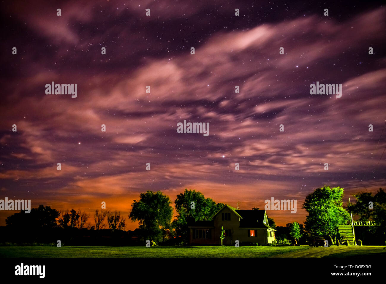 Ciel nuageux Ciel de nuit avec des étoiles sur une maison rurale à distance Banque D'Images Ciel nuageux Ciel de nuit avec des étoiles sur une maison rurale à distance Banque D'Images