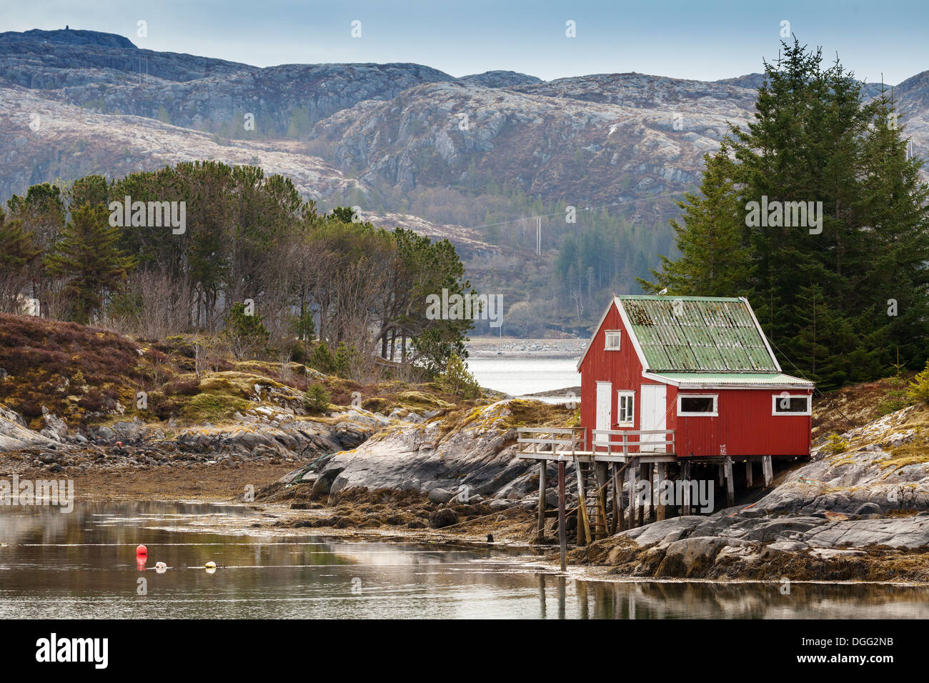 Maison en bois rouge se dresse sur la côte de la mer de Norvège Banque D'Images