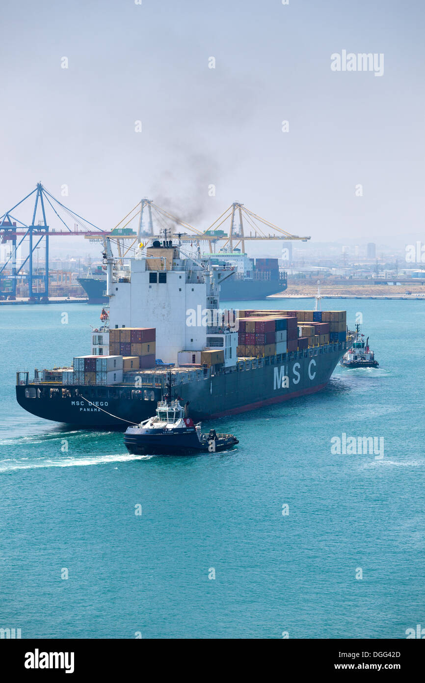 Grand navire à conteneurs « MSC DIEGO » entrant dans le port de Valence en Espagne avec tugs aidant Banque D'Images