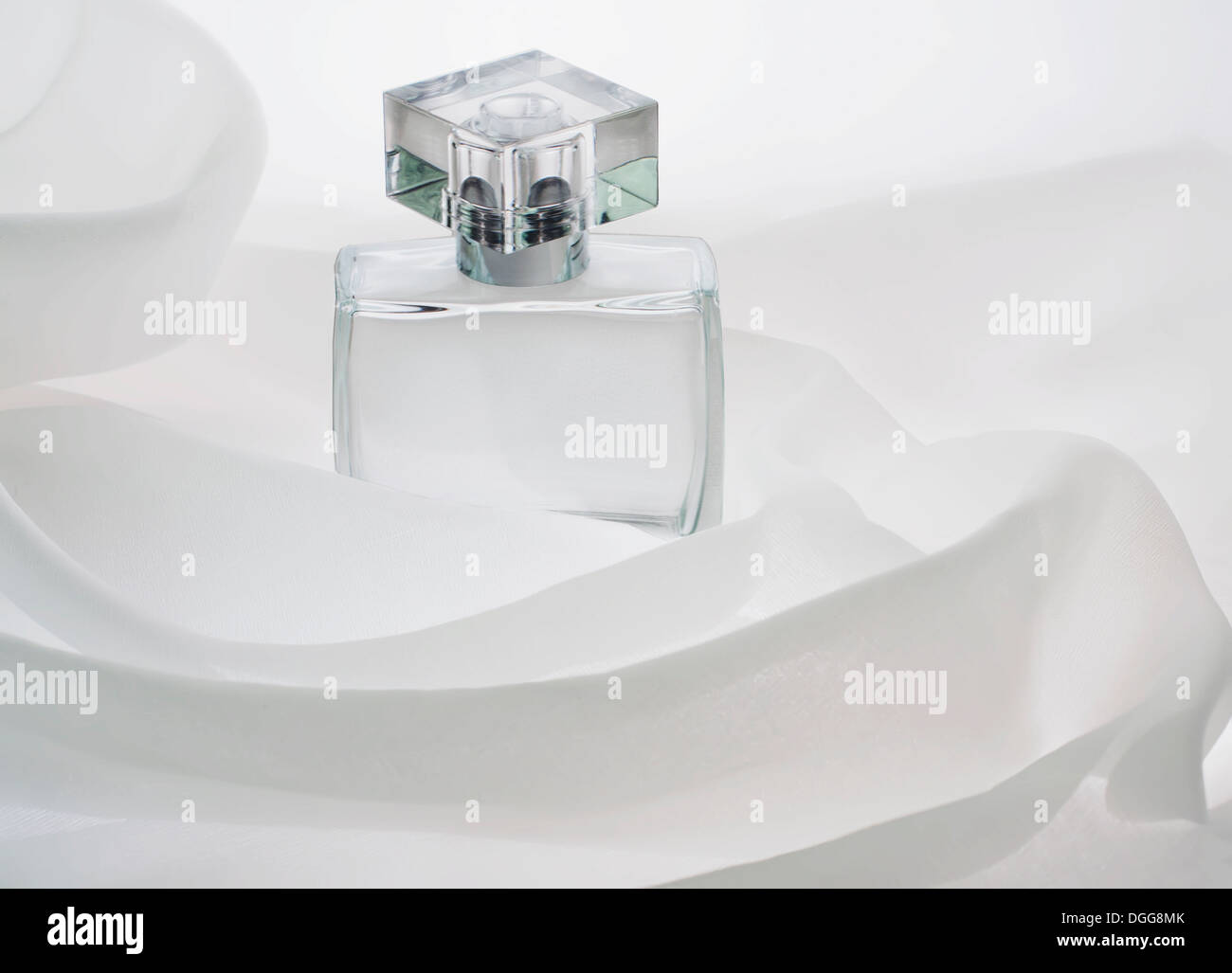 Flacons de parfum, vide, seul, est enfoui dans les plis de l'air, des nuages de tissu blanc Banque D'Images