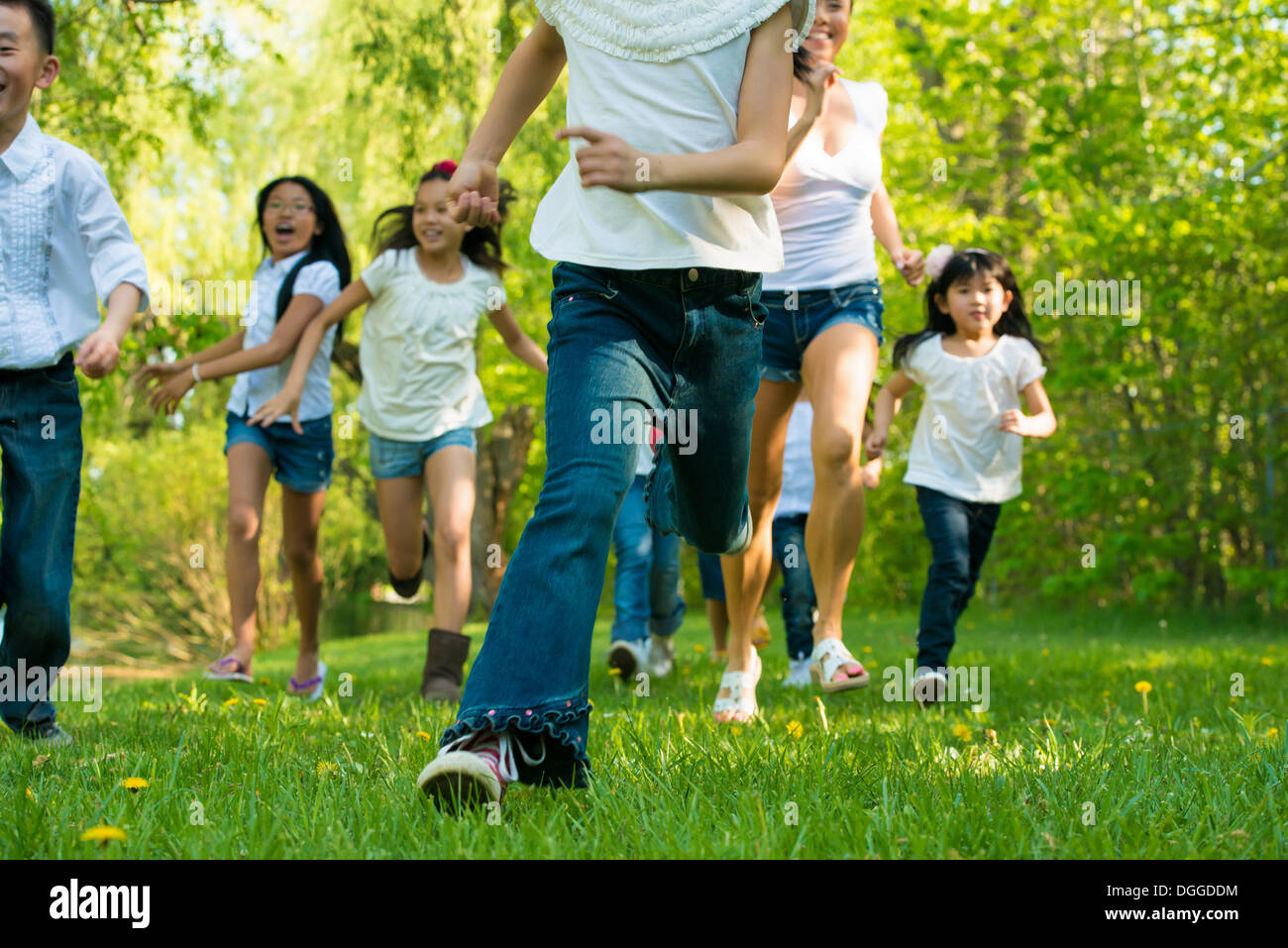 Les garçons et les filles running in park Banque D'Images