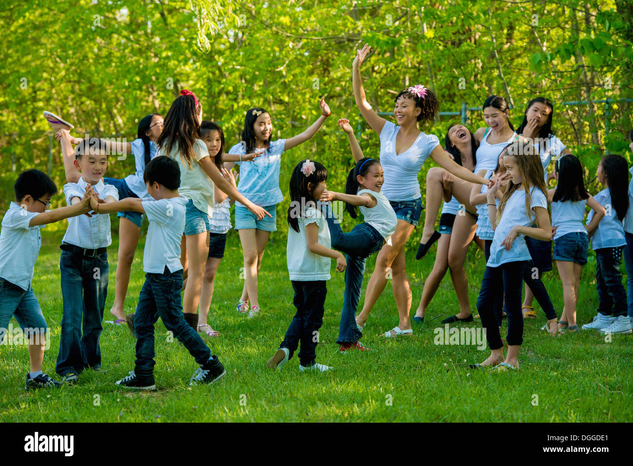 Grand groupe d'enfants dansant dans park Banque D'Images