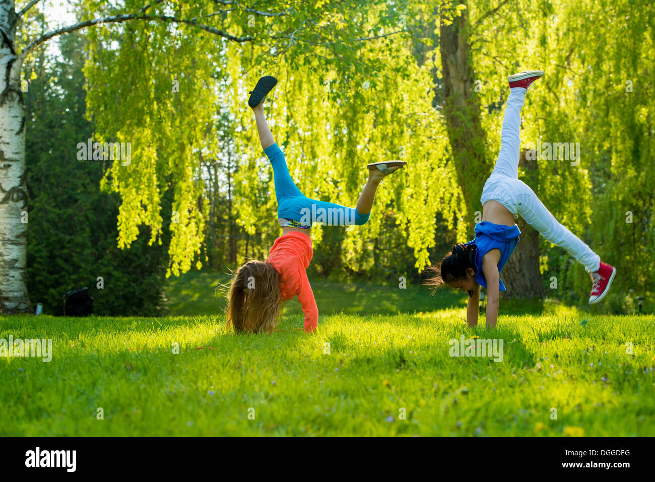 Deux filles faisant handstands in park Banque D'Images