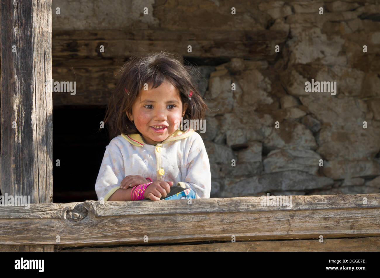 Petite fille locale appuyée sur un poteau en bois, Sete, district de Solukhumbu, Sagarmāthā Zone, Népal Banque D'Images
