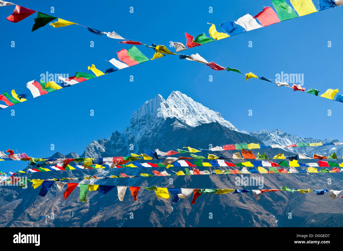 Drapeaux de prière bouddhiste en face de la montagne au-dessus de Namche Bazar Kangtega (3,440 m), la base pour le trekking et l'alpinisme dans Banque D'Images