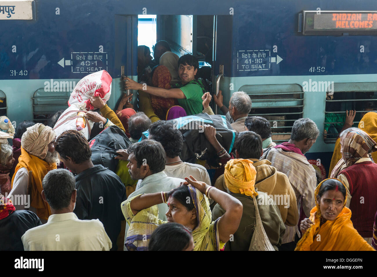 Des foules de gens poussant à l'intérieur d'un train, sur une plate-forme de la gare, Allahabad, Uttar Pradesh, Inde Banque D'Images