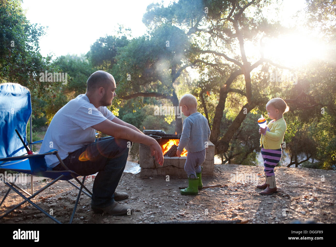 Toddler twins sur site de camping avec le père Banque D'Images