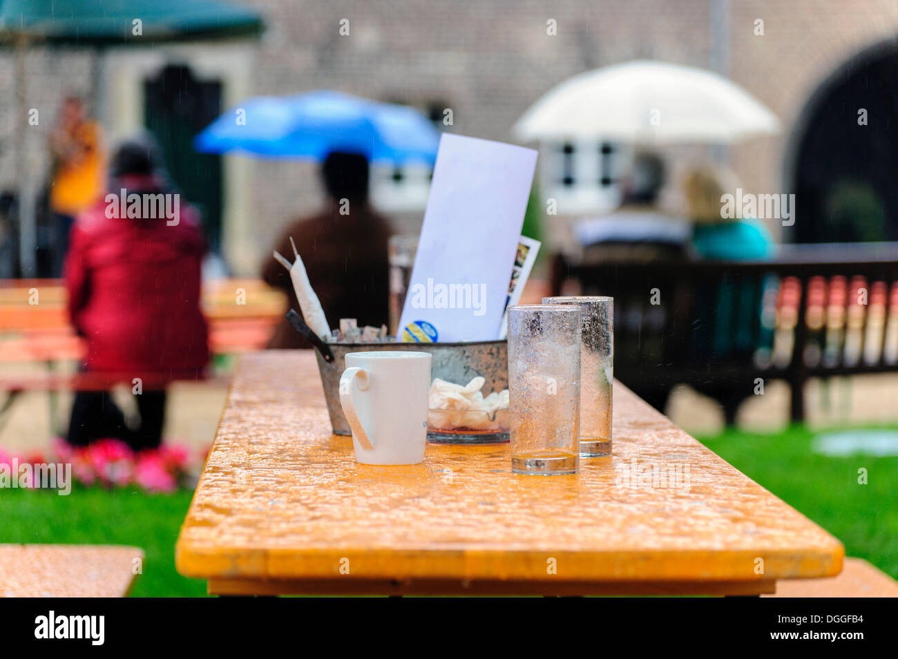 Une table avec des verres vides et une tasse de café sous la pluie, Paffendorf, Rhénanie du Nord-Westphalie Banque D'Images