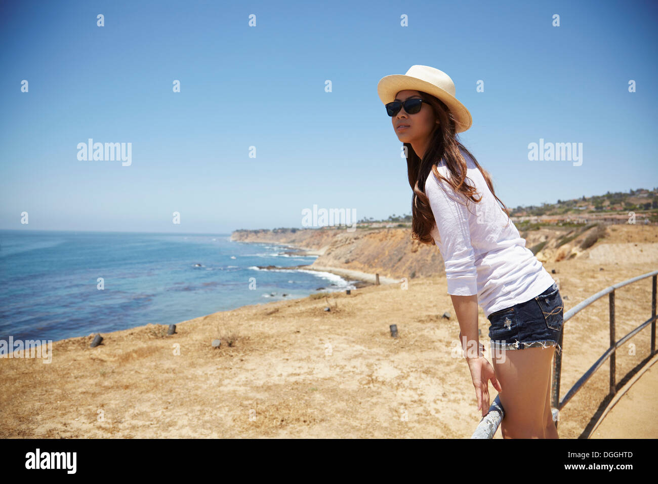 Young woman standing on fence, Palos Verdes, California, USA Banque D'Images