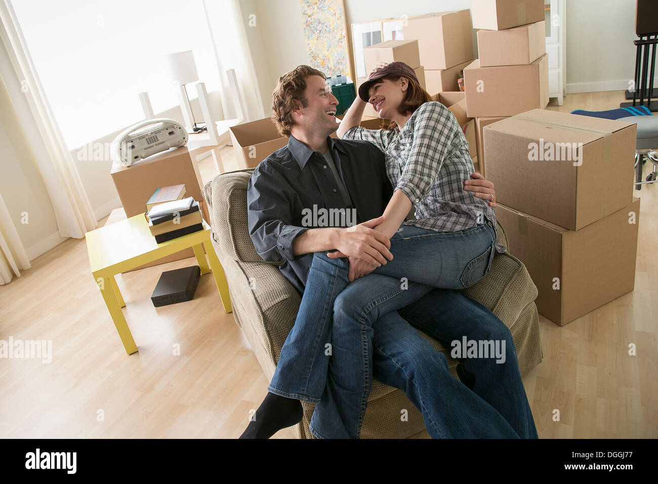 Couple en faisant une pause dans un fauteuil alors que le déménagement Banque D'Images