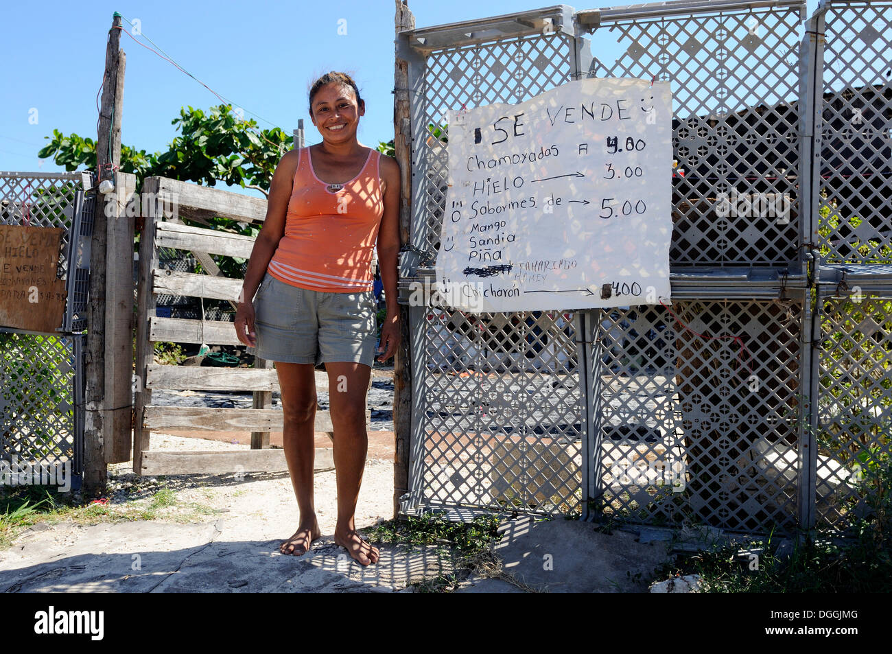 Femme debout devant sa maison dans un taudis, elle vend des sucreries faites maison pour augmenter le budget de la famille, Cancun Banque D'Images