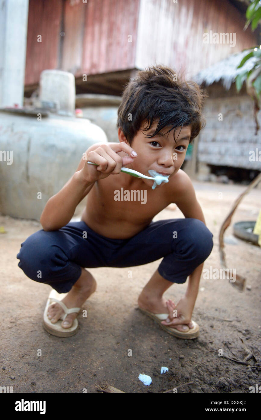 Jeune garçon se brosser les dents à l'extérieur une maison Lompong, commune, district, Province de Takéo Bathi, Cambodge Banque D'Images