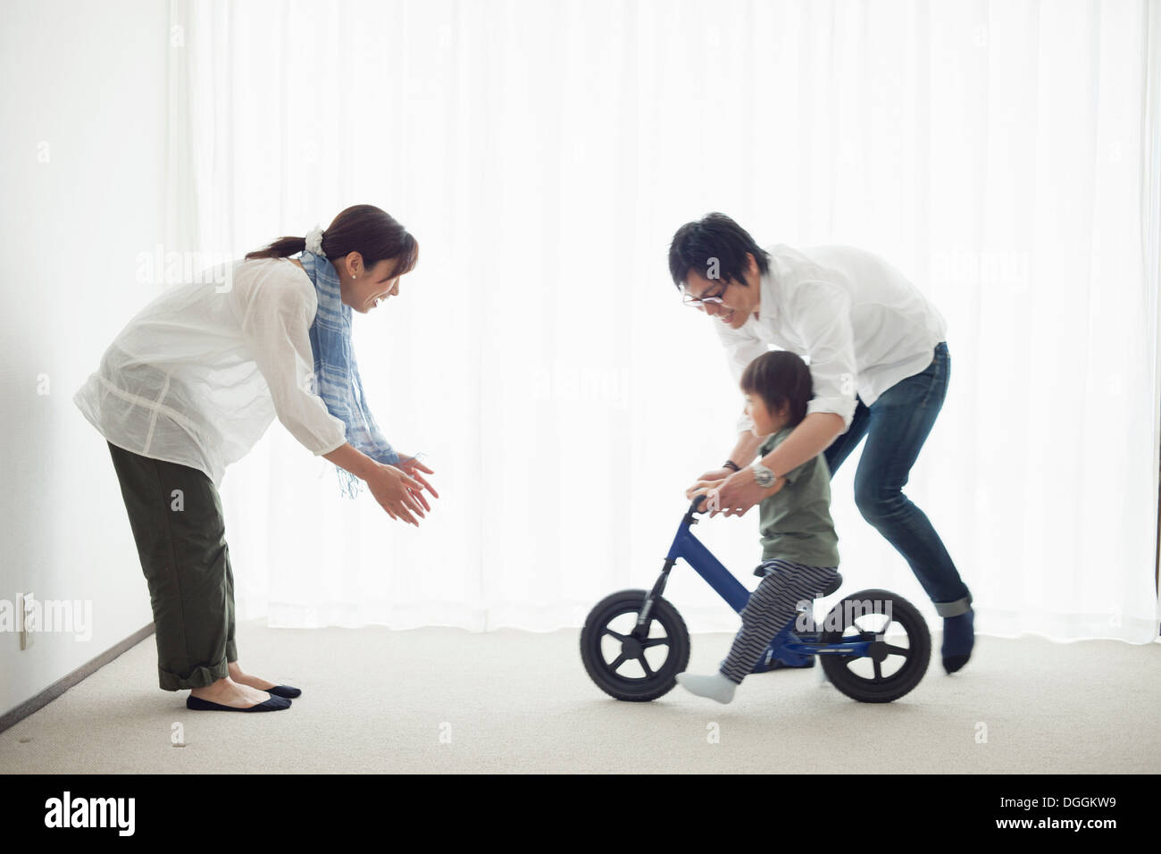 Les parents avec son fils à apprendre à faire du vélo location Banque D'Images