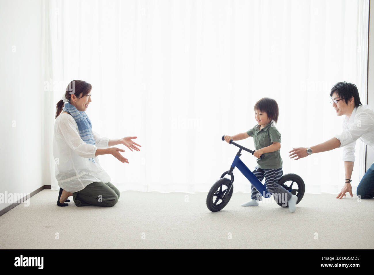 Les parents avec son fils à apprendre à faire du vélo location Banque D'Images