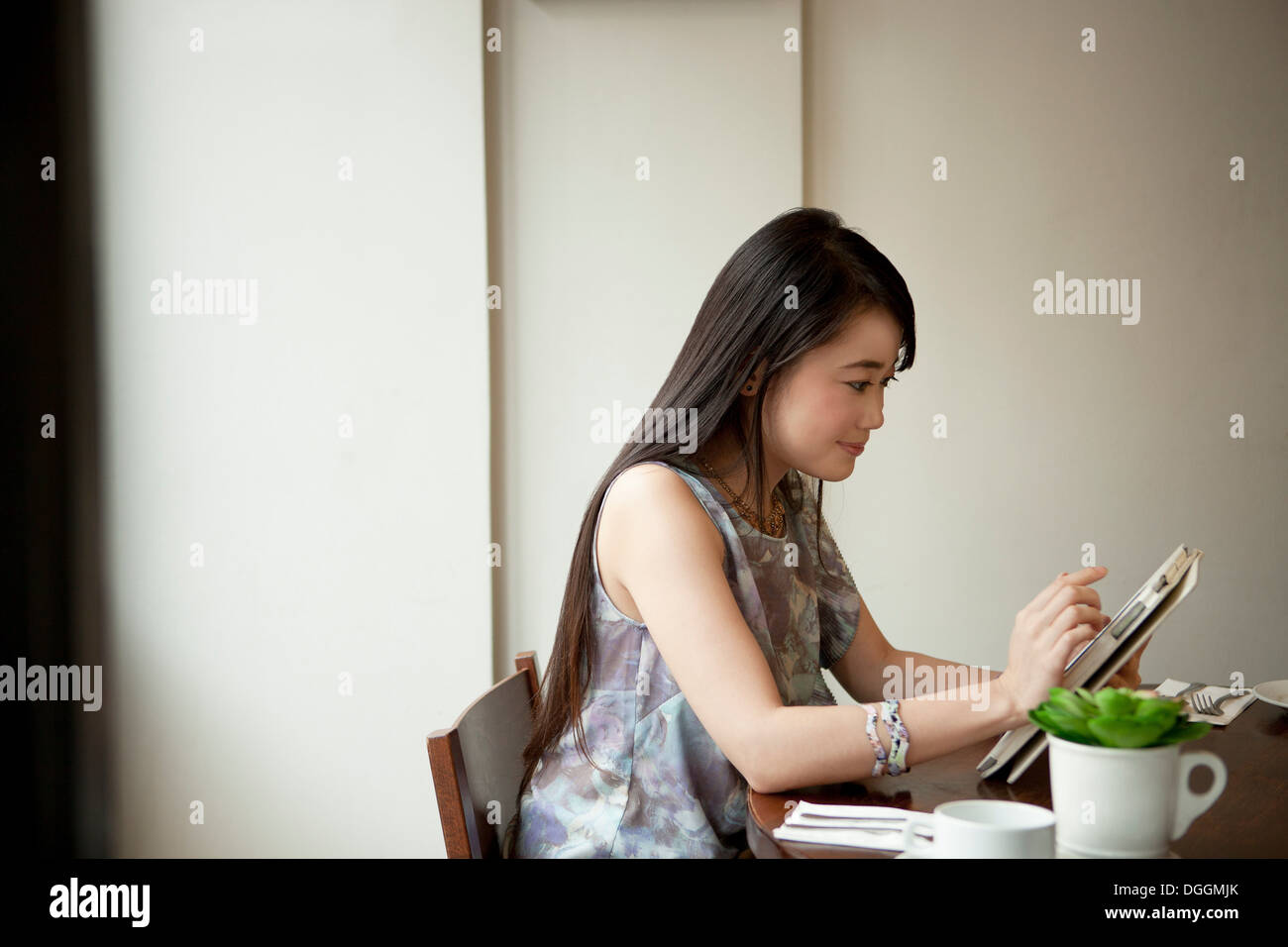 Young woman using digital tablet in restaurant Banque D'Images