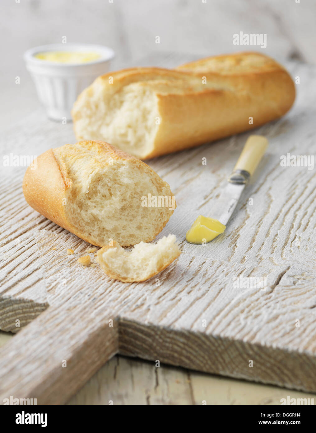 Baguette avec du beurre blanc sur blanc bois Banque D'Images