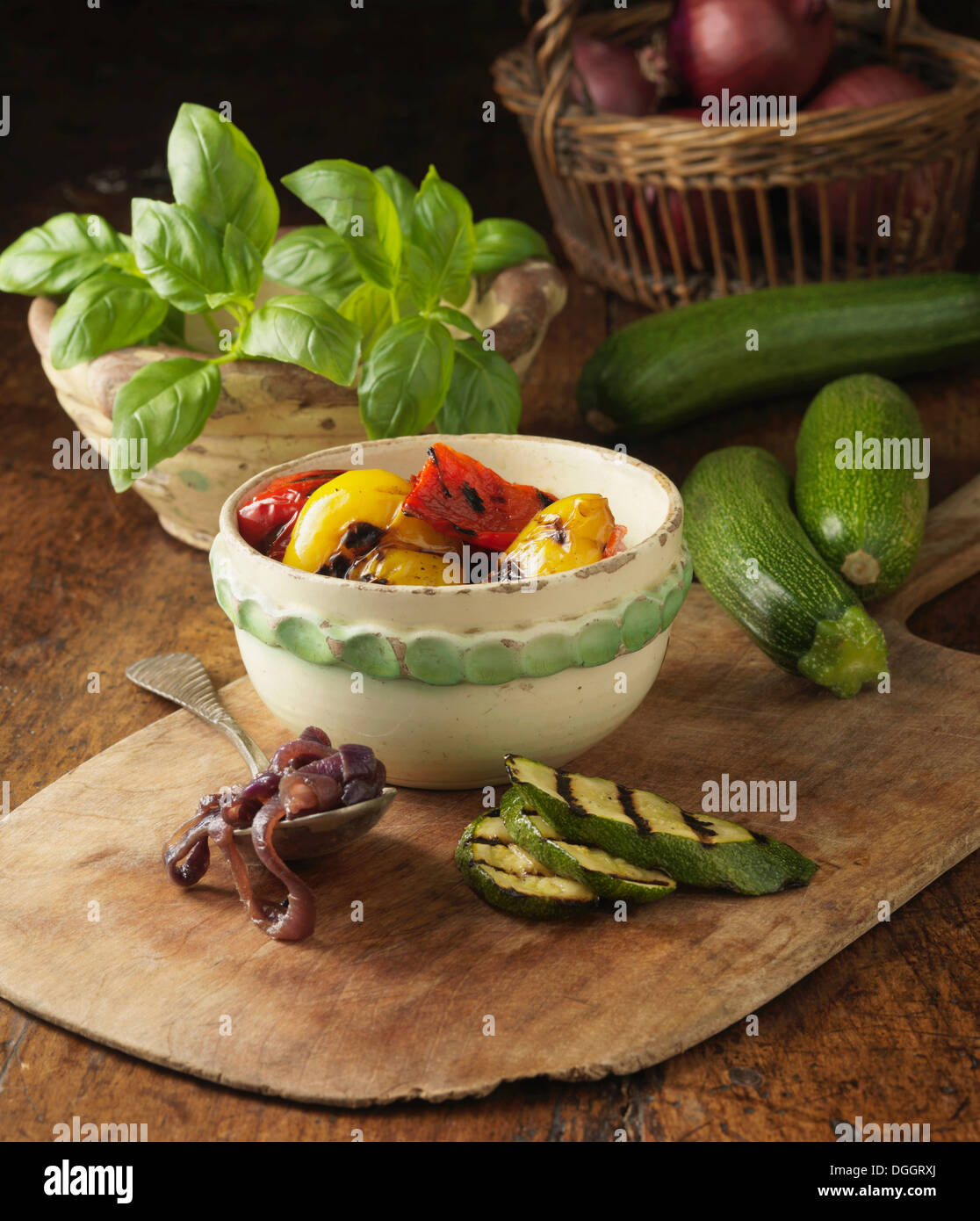 Ingrédients pour char et légumes grillés au pesto de basilic sur pizza pizza rustique board Banque D'Images