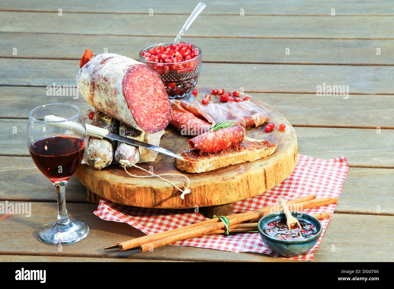 Le salami sur planche à découper avec du vin et condiments Banque D'Images