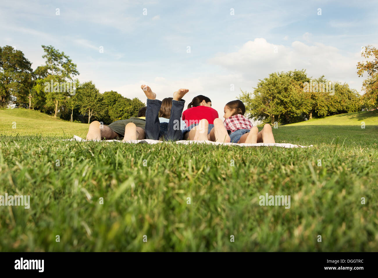 Famille avec deux enfants allongés sur l'herbe, vue arrière Banque D'Images