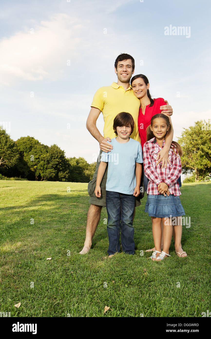 Portrait de famille avec deux enfants debout sur l'herbe Banque D'Images
