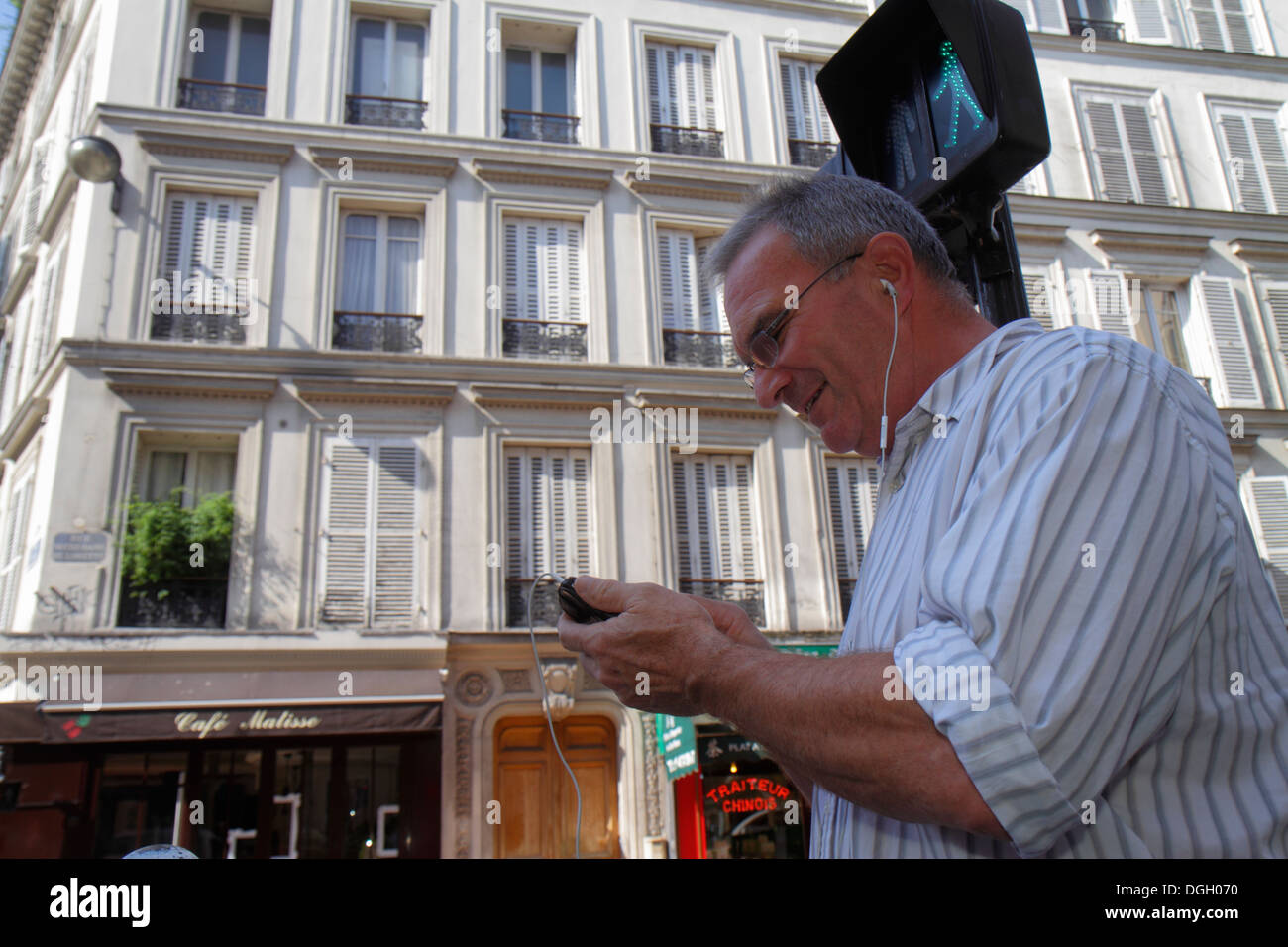 Paris France,9ème arrondissement,rue notre-Dame de Lorette,homme hommes,utilisation,smartphone,téléphones,écouteurs,vérifier la lecture de messages texte,co Banque D'Images