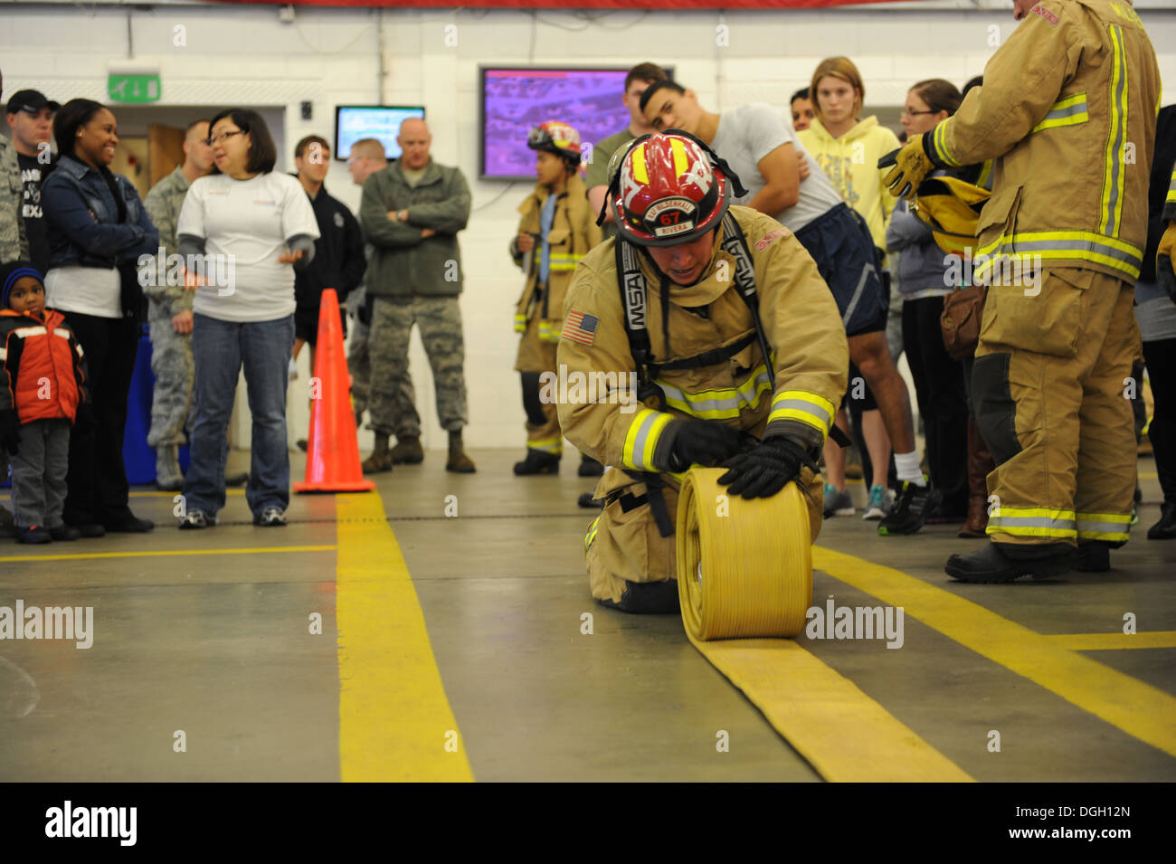 Le sergent de l'US Air Force. Noel Rivera Saldana, 100e Escadron de génie civile Pompiers pompier, l'équipe indique les membres de Mildenhall comment rouler un flexible avant le troisième feu annuel Muster 10 octobre 2013, sur RAF Mildenhall, Angleterre. Mildenhall équipe m Banque D'Images